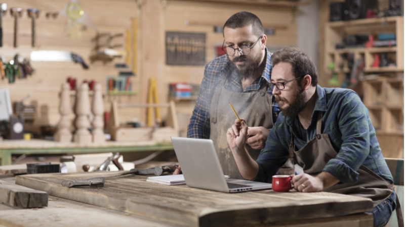 Business owners using a laptop in a workshop
