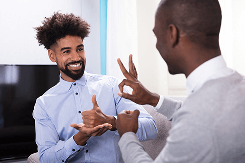 Image of two men communicating using sign language