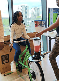 A child on a bike with a blender