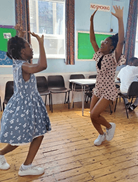 Two girls dancing in a classroom