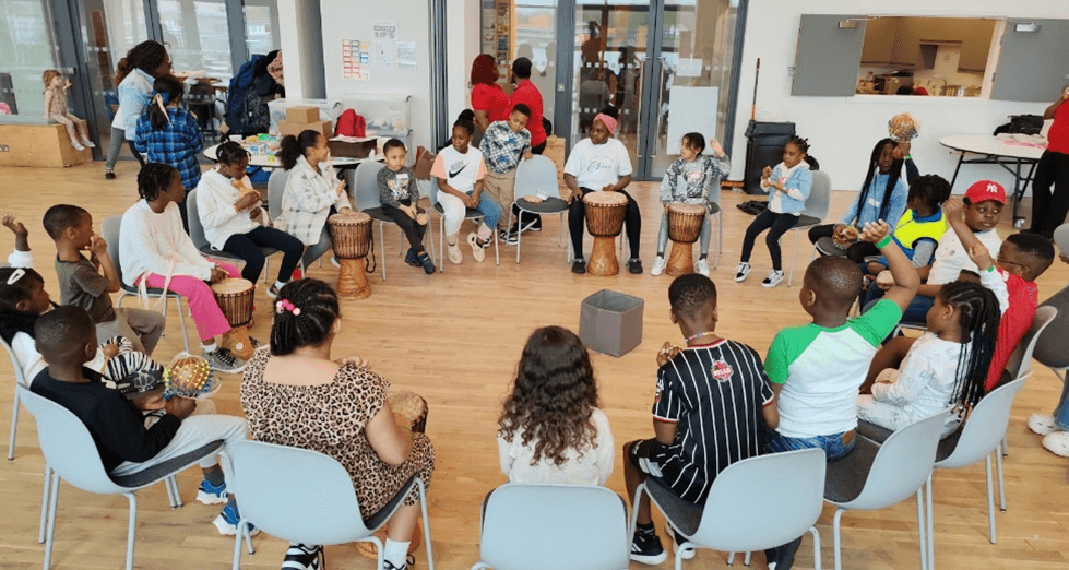 A group of children playing drums in a room
