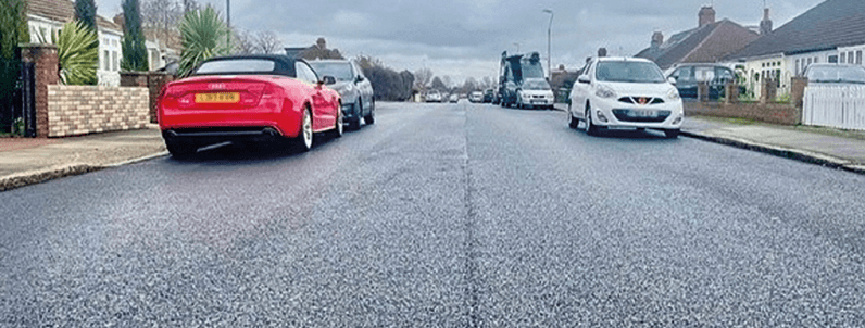 A road showing a couple of parked cars