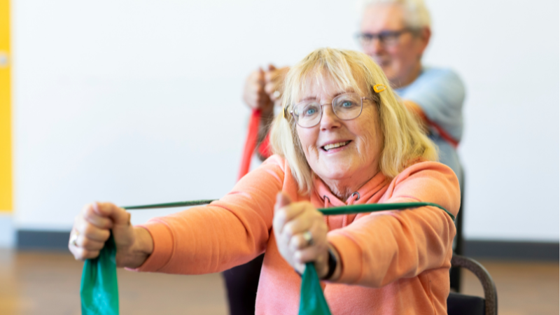 old resident with glasses exercising in a community space
