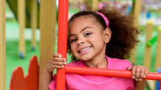 Happy young girl smiling and playing on a playground