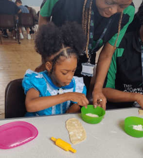 A child making food at a table