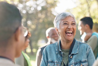 Decorative image of a women laughing with other members of the community