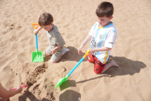 children playing with sand at the beach