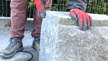 Artist moulding the granite in Erith