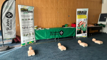 St John's ambulance stand with dolls on the floor for CPR training. 